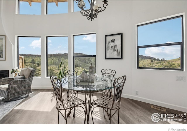 2118 Dry Creek Dr, Lyons, CO 80540 - dining space with wood finished floors, baseboards, healthy amount of natural light, a chandelier, and a high ceiling