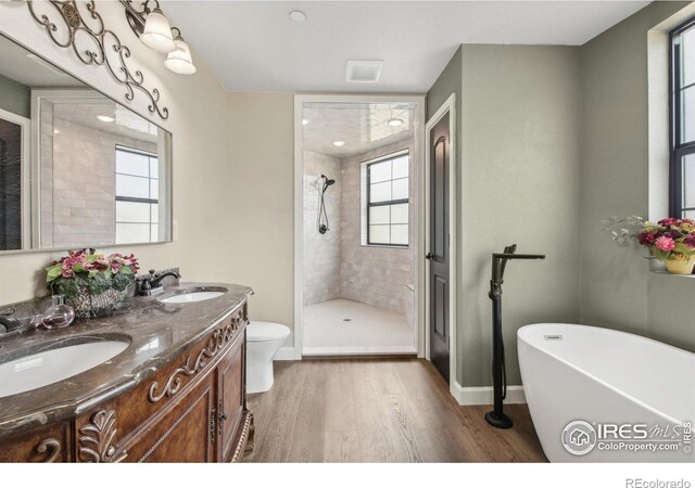 2118 Dry Creek Dr, Lyons, CO 80540 - bathroom featuring wood finished floors, a shower stall, a freestanding tub, double vanity, and baseboards