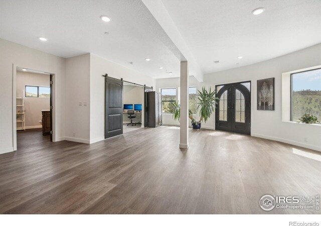 2118 Dry Creek Dr, Lyons, CO 80540 - unfurnished living room featuring a barn door, french doors, recessed lighting, baseboards, and wood finished floors