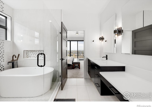 full bathroom featuring connected bathroom, vanity, a freestanding tub, and tile patterned floors