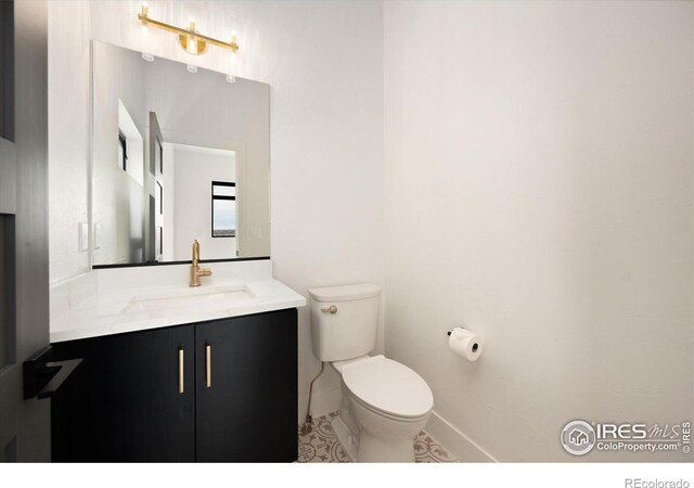 bathroom featuring toilet, vanity, and tile patterned flooring