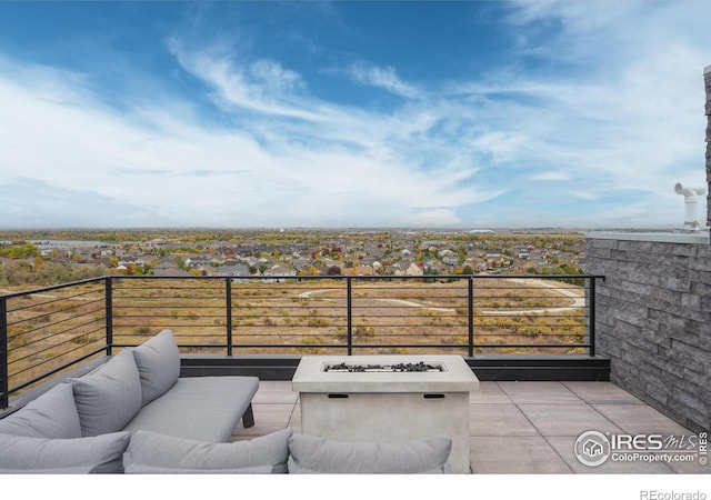 view of patio / terrace with an outdoor living space with a fire pit and a balcony