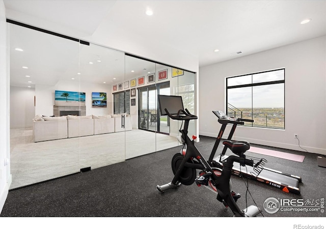 exercise room featuring a fireplace, recessed lighting, and baseboards