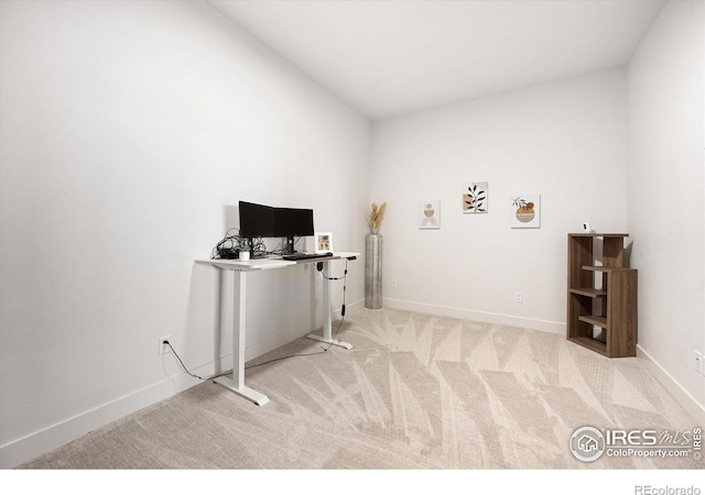 carpeted office space featuring baseboards and lofted ceiling