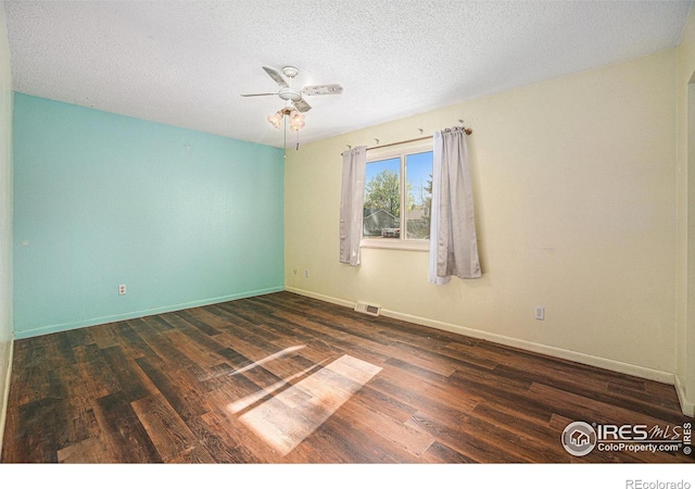 spare room featuring dark wood-style floors, ceiling fan, baseboards, and a textured ceiling