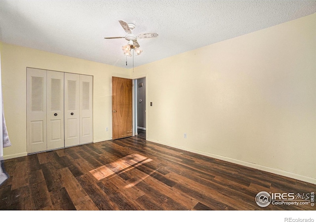 unfurnished bedroom with wood finished floors, baseboards, a closet, and a ceiling fan