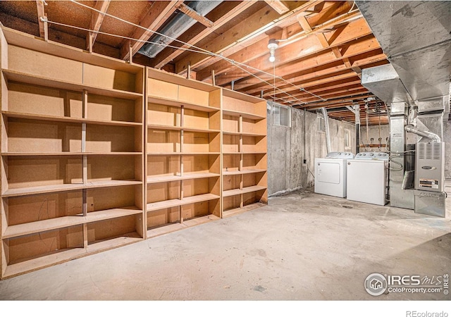 unfinished below grade area featuring washing machine and dryer and heating unit