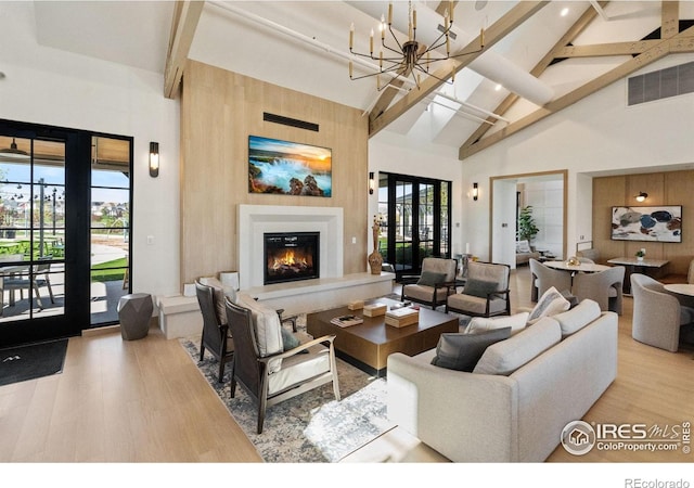 97 Westerly Blvd, Erie, CO 80516 - living area with high vaulted ceiling, beam ceiling, wood finished floors, a glass covered fireplace, and plenty of natural light