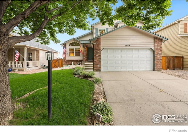 3949 Willowood Ave, Loveland, CO 80538 - view of front facade with brick siding, a garage, and driveway