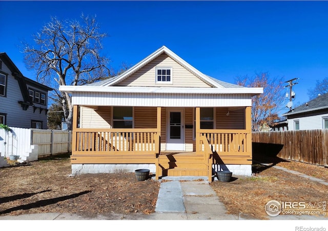 view of front of house featuring covered porch and fence
