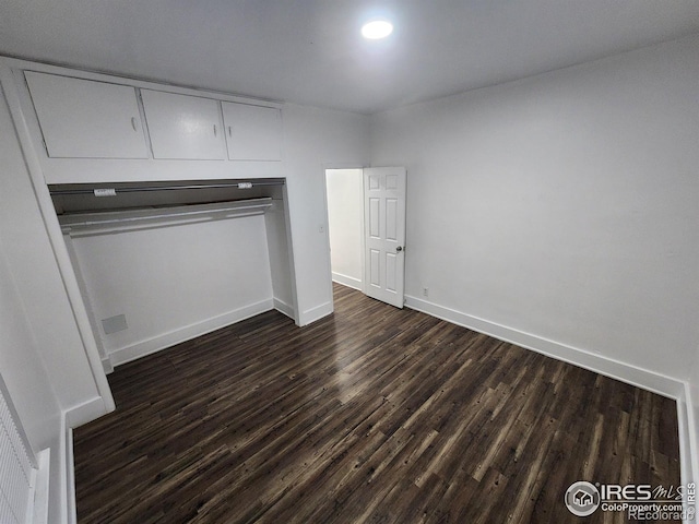 unfurnished bedroom with dark wood finished floors and baseboards