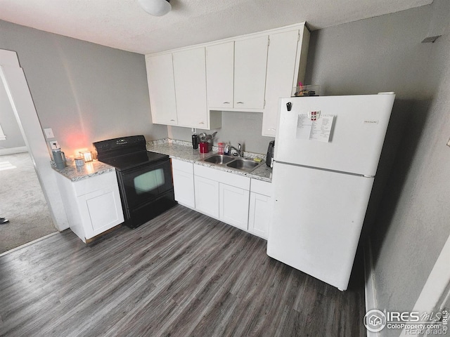 kitchen with black electric range, freestanding refrigerator, a sink, dark wood finished floors, and a textured ceiling