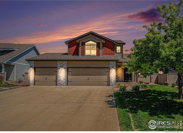 8962 Smoke Signal Way, Wellington, CO 80549 - traditional home featuring concrete driveway, brick siding, a garage, and a shingled roof