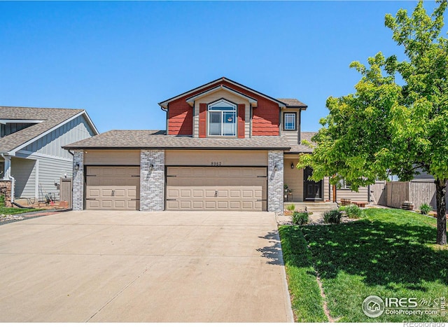 8962 Smoke Signal Way, Wellington, CO 80549 - view of front of house with concrete driveway, brick siding, roof with shingles, and an attached garage