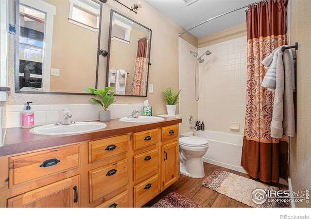 8962 Smoke Signal Way, Wellington, CO 80549 - bathroom featuring wood finished floors, toilet, double vanity, shower / bath combo, and decorative backsplash