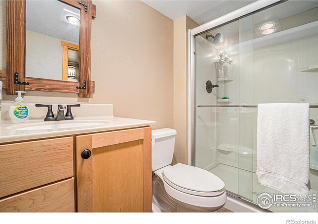 8962 Smoke Signal Way, Wellington, CO 80549 - bathroom featuring toilet, a shower stall, and vanity