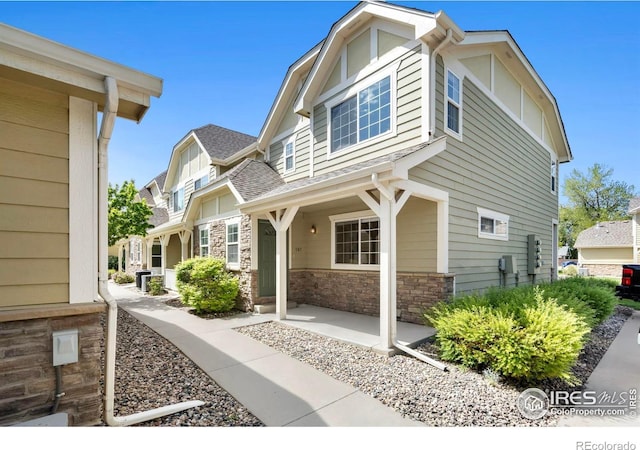 1014 Andrews Peak Dr Unit B107, Fort Collins, CO 80521 - view of side of property featuring stone siding and a shingled roof