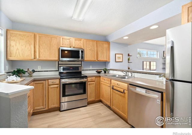 1014 Andrews Peak Dr Unit B107, Fort Collins, CO 80521 - kitchen with appliances with stainless steel finishes, a sink, light wood-type flooring, light brown cabinetry, and recessed lighting