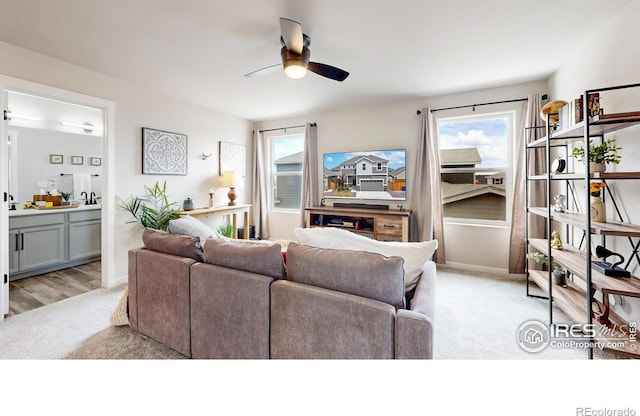 living room with light colored carpet and ceiling fan