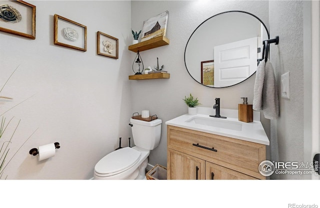 half bathroom with toilet and vanity