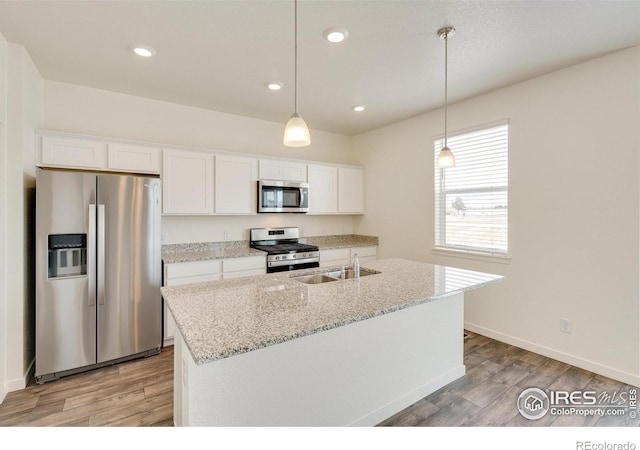 332 Hummingbird Ln, Johnstown, CO 80534 - kitchen featuring appliances with stainless steel finishes, a sink, light wood finished floors, white cabinets, and recessed lighting