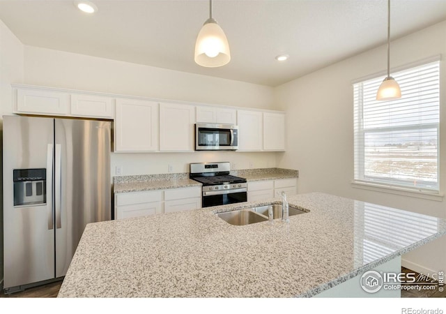 332 Hummingbird Ln, Johnstown, CO 80534 - kitchen featuring stainless steel appliances, a sink, white cabinetry, light stone counters, and recessed lighting