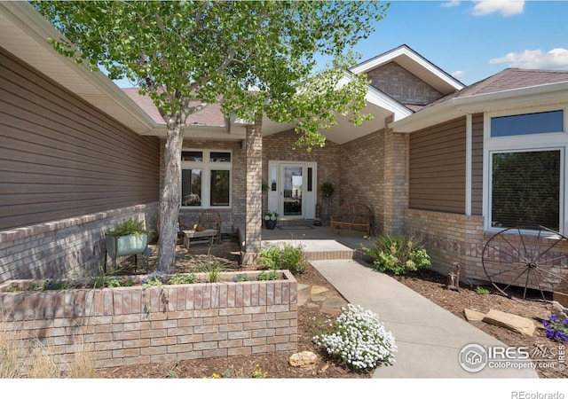 property entrance with brick siding and a porch