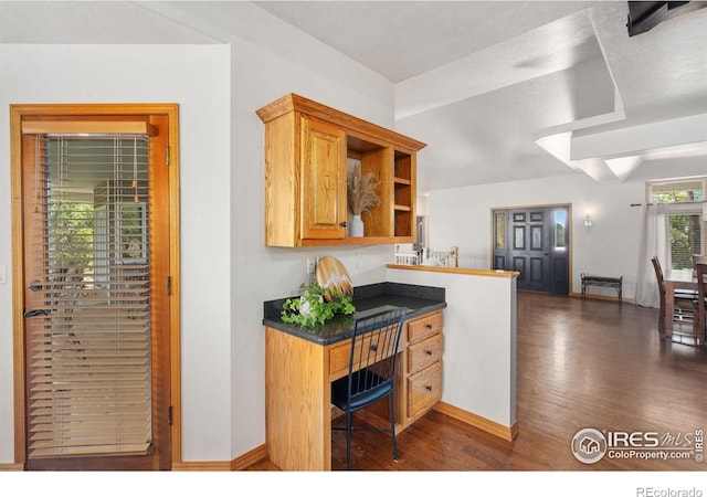 kitchen featuring dark wood-style flooring, baseboards, open shelves, and dark countertops