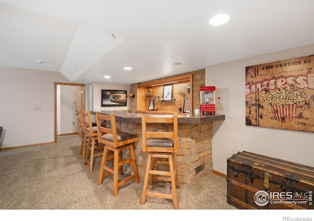 indoor wet bar featuring light carpet, baseboards, recessed lighting, and vaulted ceiling