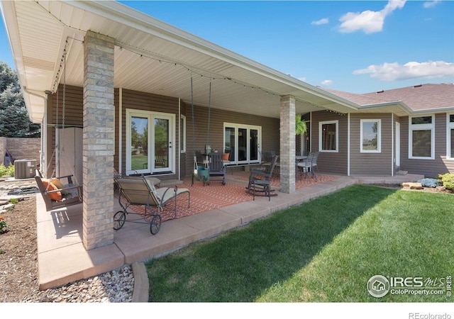 back of property featuring a lawn, a patio area, and central air condition unit