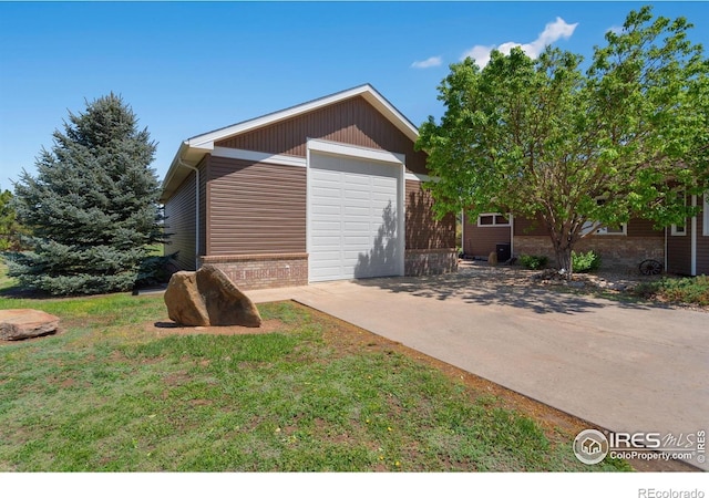view of side of home with concrete driveway, brick siding, and a garage