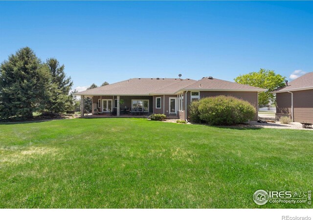 back of house with a lawn and a patio area