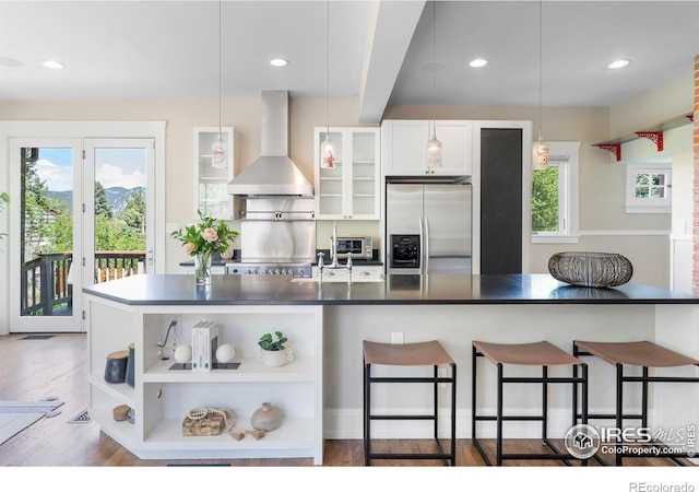 721 9th St, Boulder, CO 80302 - kitchen featuring stainless steel fridge with ice dispenser, wall chimney range hood, open shelves, dark countertops, and healthy amount of natural light