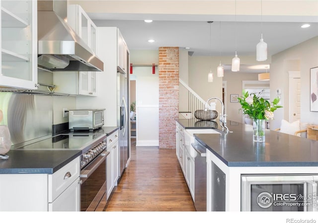 721 9th St, Boulder, CO 80302 - kitchen with wall chimney range hood, stainless steel appliances, dark countertops, a sink, and recessed lighting