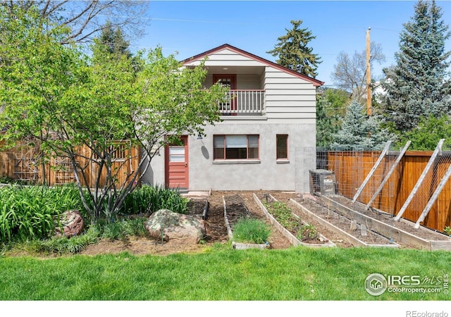 721 9th St, Boulder, CO 80302 - rear view of house featuring a balcony, a vegetable garden, stucco siding, and central AC