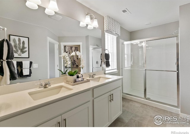 full bathroom featuring a shower stall and double vanity