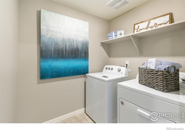 laundry area with washer and clothes dryer and baseboards
