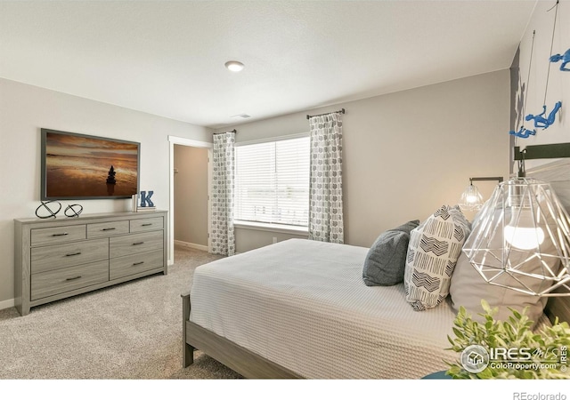 bedroom featuring light carpet and baseboards