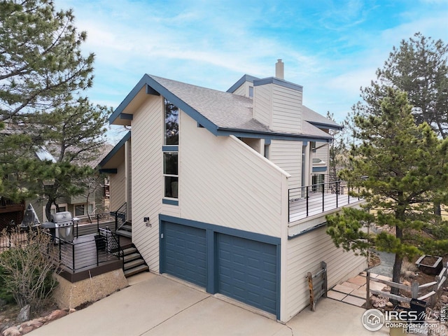 3075 Galena Way, Boulder, CO 80305 - view of side of home with a chimney, driveway, a garage, a shingled roof, and stairway