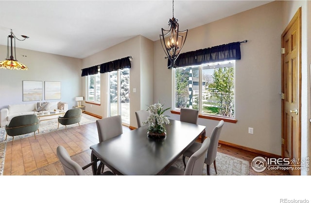 4447 Twin Peaks Dr, Loveland, CO 80537 - dining space featuring wood finished floors, a chandelier, and baseboards
