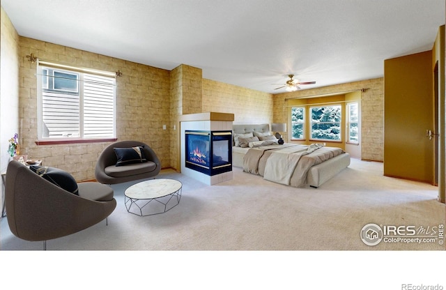 4447 Twin Peaks Dr, Loveland, CO 80537 - bedroom featuring carpet, a multi sided fireplace, brick wall, and ceiling fan