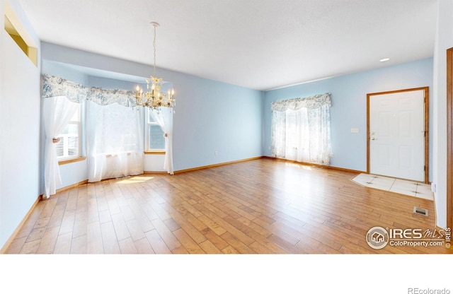 4447 Twin Peaks Dr, Loveland, CO 80537 - spare room with a chandelier, wood finished floors, and baseboards