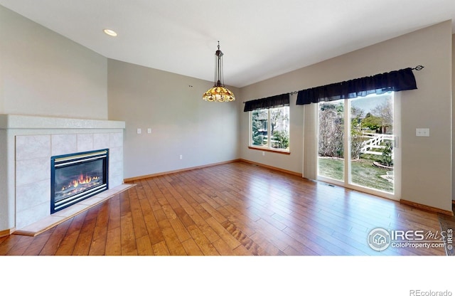 4447 Twin Peaks Dr, Loveland, CO 80537 - unfurnished living room with wood-type flooring, a tile fireplace, and baseboards