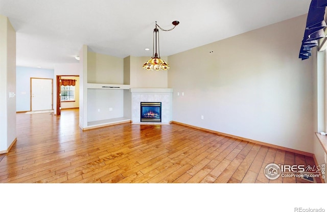 4447 Twin Peaks Dr, Loveland, CO 80537 - unfurnished living room featuring light wood-style flooring, baseboards, and a fireplace