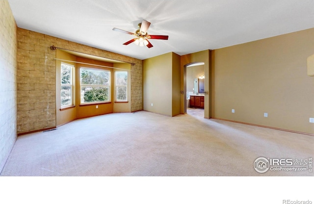4447 Twin Peaks Dr, Loveland, CO 80537 - empty room featuring arched walkways, ceiling fan, light colored carpet, and baseboards