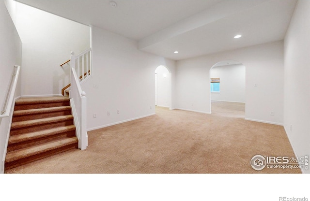 4447 Twin Peaks Dr, Loveland, CO 80537 - below grade area featuring light colored carpet, recessed lighting, arched walkways, stairs, and baseboards