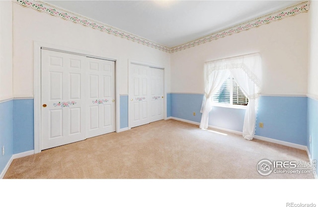 4447 Twin Peaks Dr, Loveland, CO 80537 - unfurnished bedroom with multiple closets, carpet floors, and baseboards