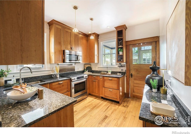 486 N Corona St, Denver, CO 80218 - kitchen with stainless steel appliances, light wood-style flooring, brown cabinetry, and pendant lighting