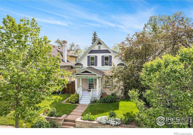 486 N Corona St, Denver, CO 80218 - view of front facade with a porch, a front yard, and a chimney