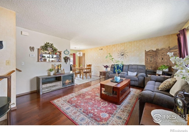 127 Lori Dr, Loveland, CO 80537 - living room featuring wood finished floors, a chandelier, a textured ceiling, wallpapered walls, and baseboards